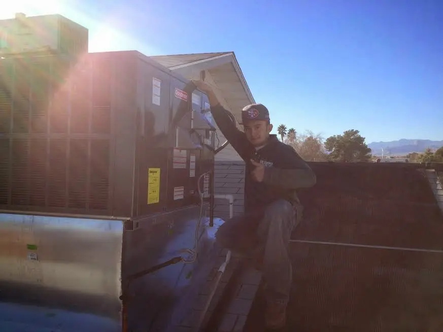 HVAC technician performing HVAC Inspection on a rooftop unit in Westfield
